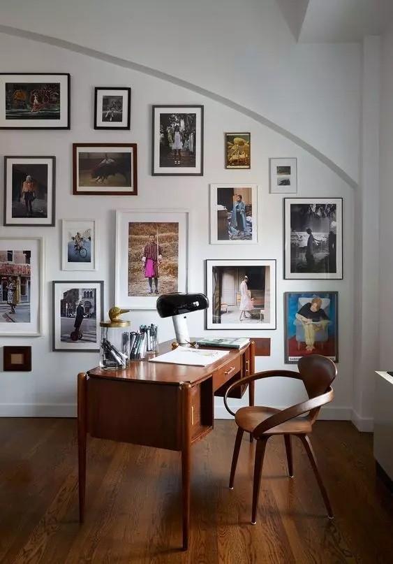 a-beautiful-and-refined-home-office-with-a-rich-stained-desk-and-a-chair-a-colorful-gallery-wall-on-an-arched-wall-1.jpg