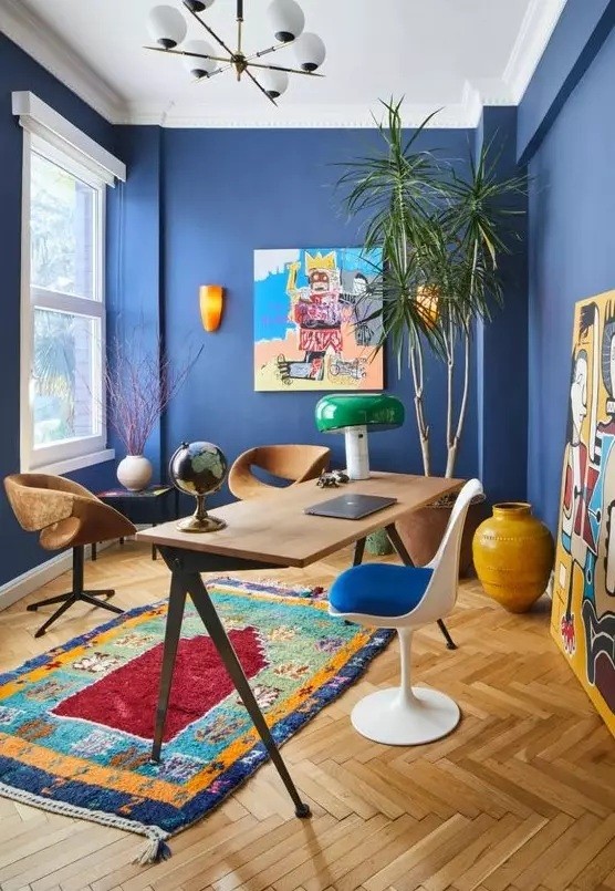 a-vibrant-home-office-with-bold-blue-walls-colorful-artworks-and-a-rug-mismatching-chairs-and-a-statement-plant-in-the-corner.jpg