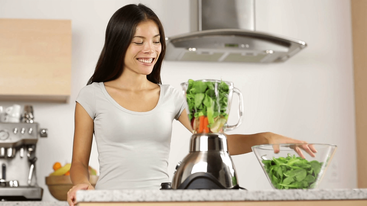 videoblocks-woman-making-green-vegetable-smoothie-putting-spinach-in-blender-and-blending-smoothies-healthy-eating-lifestyle-with-young-woman-preparing-drink-with-spinach-carrots-celery-at-home-in-kitc.png