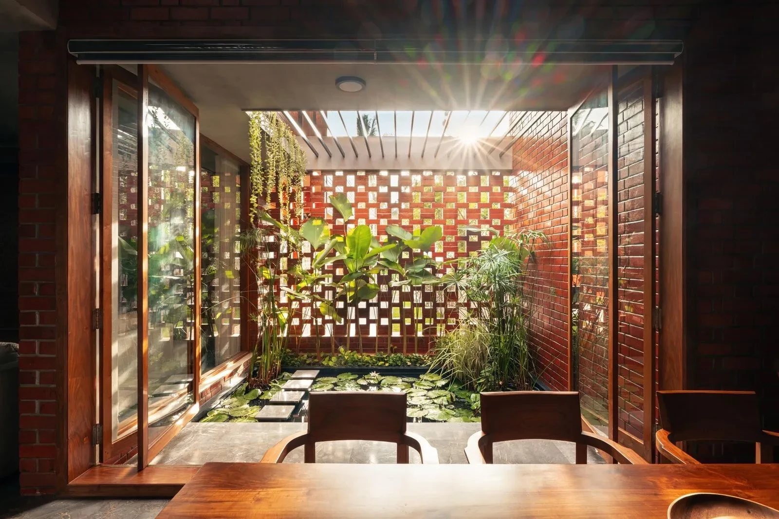 16-the-kenzjpg-dining-opening-out-to-green-pool-courtyard.webp