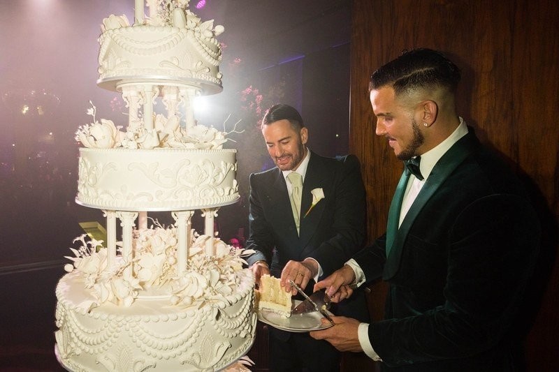 the-grooms-cutting-into-their-five-tier-wedding-cake-by-ron-ben-israel.jpg