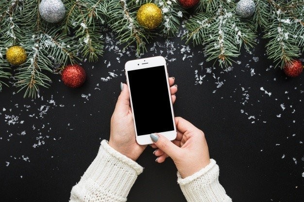 christmas-composition-with-hands-holding-smartphone-23-2147722704.jpg