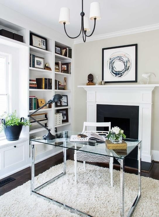 glass-stainless-steel-desk-in-front-of-fireplace-reed-small-chandelier.jpg