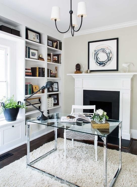 glass-stainless-steel-desk-in-front-of-fireplace-reed-small-chandelier.jpeg